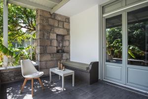 una veranda con panchina, sedia e tavolo di Melagrana ad Adámas