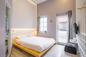 a small bedroom with a bed and a window at Norn Yaowarat Hotel in Bangkok
