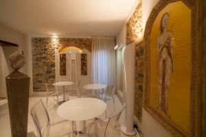 uma sala de jantar com uma mesa e um quadro na parede em Art Boutique Hotel Acchiappasogni em Barga