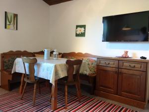 uma sala de jantar com uma mesa com cadeiras e uma televisão em Haus Erlbacher em Abtenau