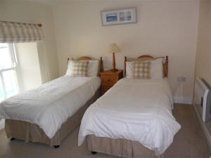 a bedroom with two beds and a window at Croi an Bháile Luxury Apartment in Rosscarbery