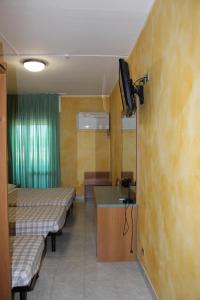 Pokój z dwoma łóżkami i telewizorem na ścianie w obiekcie Albergo Napoleone w mieście SantʼAmbrogio di Valpolicella