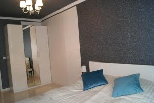 a bedroom with a bed with two blue pillows at Apartament pod zamkiem in Olsztyn