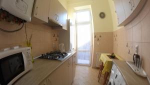 una cucina con piano cottura, lavandino e finestra di Apartment on Voloshyna a Lviv