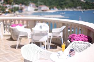 a table and chairs on a balcony with a view of the water at Boutique Hotel Kredo in Herceg-Novi