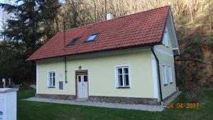 uma pequena casa branca com um telhado vermelho em Chaloupka za potůčkem em Županovice