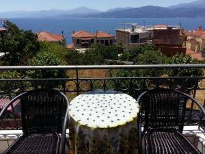 een tafel en stoelen op een balkon met uitzicht op het water bij Kristallia Rooms in Monastiraki