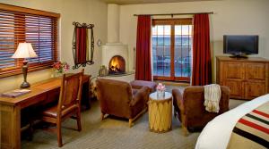 a hotel room with a desk and chairs and a bed at Eldorado Hotel and Spa in Santa Fe