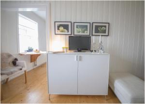 una sala de estar con un armario blanco con TV. en Bergstaðastræti Apartment, en Reikiavik 16 fotos más
