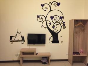 a wall sticker of a tree with hearts at 八八小屋心享民宿 in Jinning