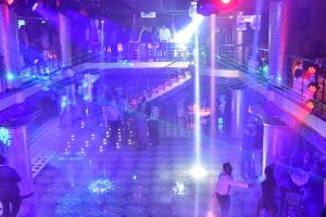 un grupo de personas de pie alrededor de una piscina en un club nocturno en Friendship International Hotel, en Addis Ababa