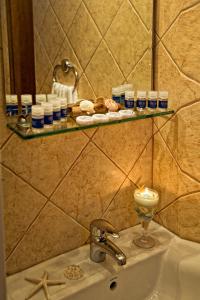 a bathroom sink with a candle on a shelf above it at Sunset Hotel in Ouranoupoli