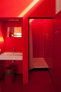 a red bathroom with a sink and a shower at WOW Amsterdam Hostel in Amsterdam