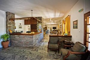 a bar in a restaurant with a stone wall at Sunset Hotel in Ouranoupoli