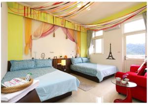a bedroom with two beds and a red couch at Hong Lai Guest House in Jiaoxi