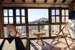 ein Wohnzimmer mit Stühlen und einem großen Fenster in der Unterkunft Lo Raconet de la Plaça in Calaceite