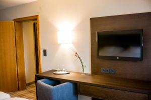 a hotel room with a table with a tv on a wall at Gasthof zum Weißen Lamm in Sommerach
