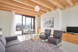 uma sala de estar com um sofá, cadeiras e uma mesa em Lake View Apartment Amsterdam em Amsterdã