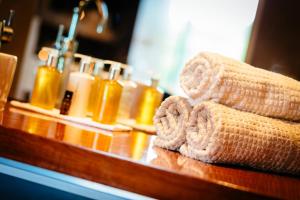 a bathroom counter with towels and bottles of soap at Ice House Hotel in Ballina