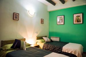 a room with a bed, a lamp, and a painting on the wall at Lo Raconet de la Plaça in Calaceite