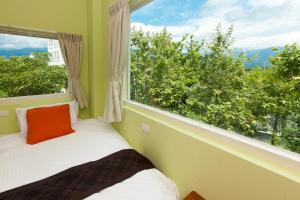 a bed in a room with a large window at Yuan Qiwu Homestay in Pinghe