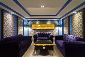 a living room with purple couches and a piano at Surreal Motel in Xinzhuang