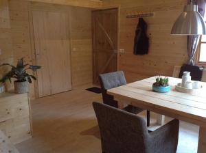 comedor con mesa de madera y sillas en Hollands Oostenrijks huisje en Wieringerwerf