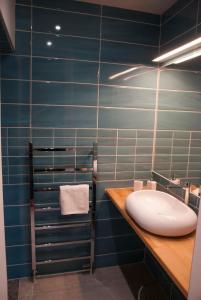 a bathroom with a sink and blue tiled walls at Appartement Du Fau De La Roque in Villefranche-de-Rouergue +20 photos