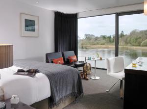 een hotelkamer met een bed en uitzicht op een rivier bij Ice House Hotel in Ballina