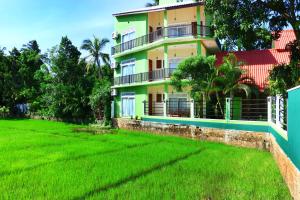 a house with a green lawn in front of it at Nature Resort in Tissamaharama