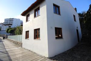 a white building with windows on the side of it at Casa do Rio Fervença in Bragança