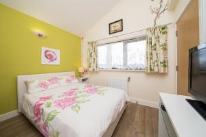 a bedroom with a bed and a flat screen tv at Rowan Park Lodge in Croydon