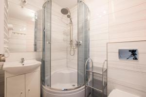 a bathroom with a shower and a toilet and a sink at Apartamenty Maja -Pokoje - Domy wakacyjne -Basen Podgrzewany -Jacuzzi in Łeba +56 photos