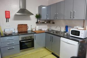 a kitchen with a sink and a microwave at Casa da Planicie in Évora