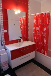 a red bathroom with a sink and a mirror at Casa da Planicie in Évora