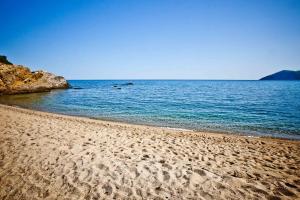 a sandy beach with a large body of water at Aselinos Suites in Koukounaries