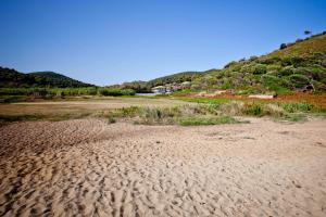 a sandy beach with a hill in the background at Aselinos Suites in Koukounaries