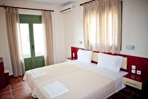 a bedroom with two beds and a green door at Aselinos Suites in Koukounaries