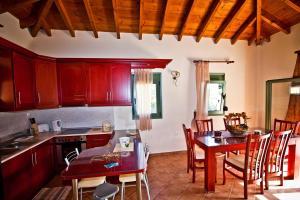 a kitchen with wooden cabinets and a table and chairs at Aselinos Suites in Koukounaries