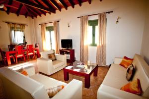 a living room with white couches and a table at Aselinos Suites in Koukounaries
