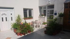 a patio with potted plants and a table and a door at Apartments Storia in Trogir