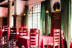 a dining room with red tables and chairs and a window at Residenza d'Epoca Albergo Quattro Fontane in Venice-Lido