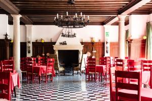 a dining room with red chairs and a fireplace at Residenza d'Epoca Albergo Quattro Fontane in Venice-Lido