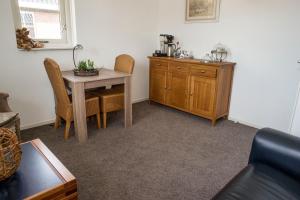 a dining room with a table and a wooden cabinet at B&B Achterhoeks Halle in Halle