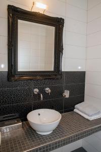 a bathroom with a white sink and a mirror at B&B Achterhoeks Halle in Halle