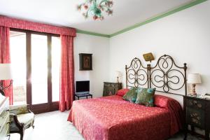 a bedroom with a bed with a red bedspread at Residenza d'Epoca Albergo Quattro Fontane in Venice-Lido