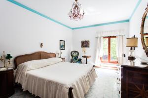 a bedroom with a bed and a chandelier at Residenza d'Epoca Albergo Quattro Fontane in Venice-Lido