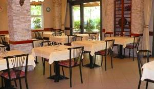 a restaurant with tables and chairs in a room at Albergo Rosa & Cosetta in Casal Borsetti