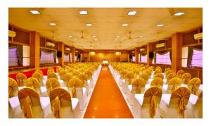 a large room with rows of chairs in a building at Hotel Aida in Kottayam