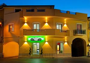 a building with a green sign in front of it at B&B 21-12 in Saviano